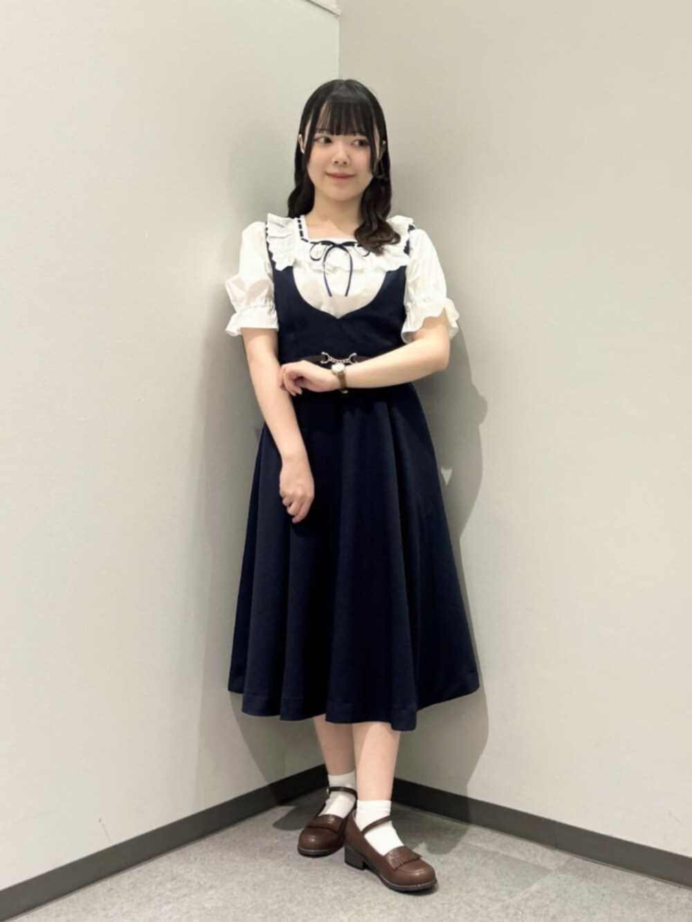 ブラウン系のローファー、ブルー系のジャンパースカート、ホワイト系のシャツ/ブラウスを着用したレディースの夏コーディネートの2枚目の写真