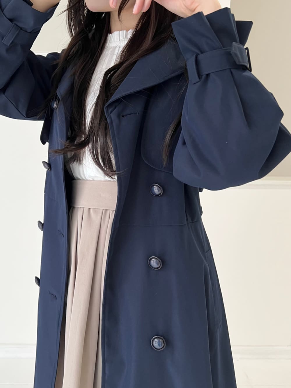 ブラック系のパンプス、ホワイト系のシャツ/ブラウス、ブルー系のトレンチコートを着用したレディースの秋コーディネートの3枚目の写真