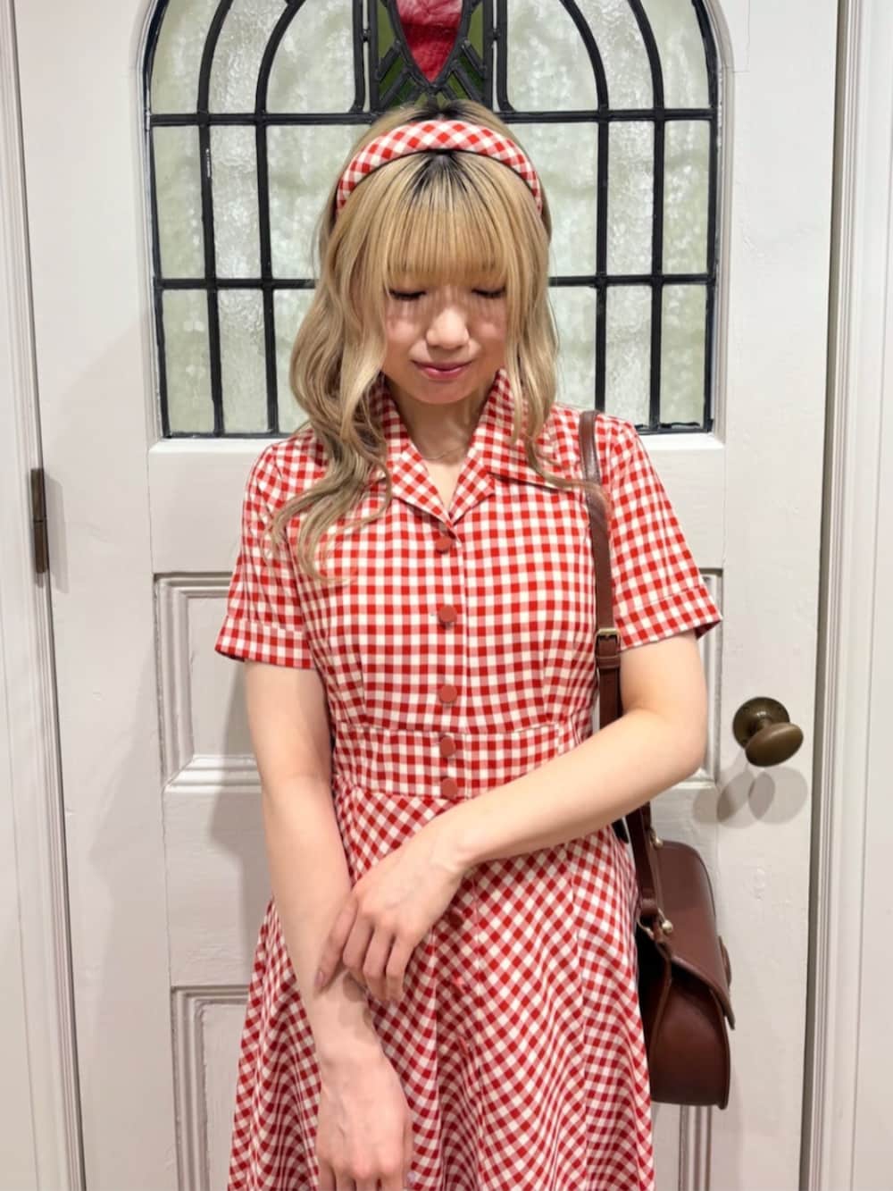 ホワイト系のワンピース、ブルー系のデニムジャケット、レッド系のパンプスを着用したレディースの春コーディネートの3枚目の写真