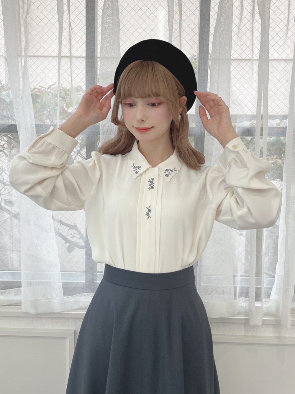 ブラック系のパンプス、ブルー系のスカート、ホワイト系のシャツ/ブラウスを着用したレディースの秋コーディネートの2枚目の写真