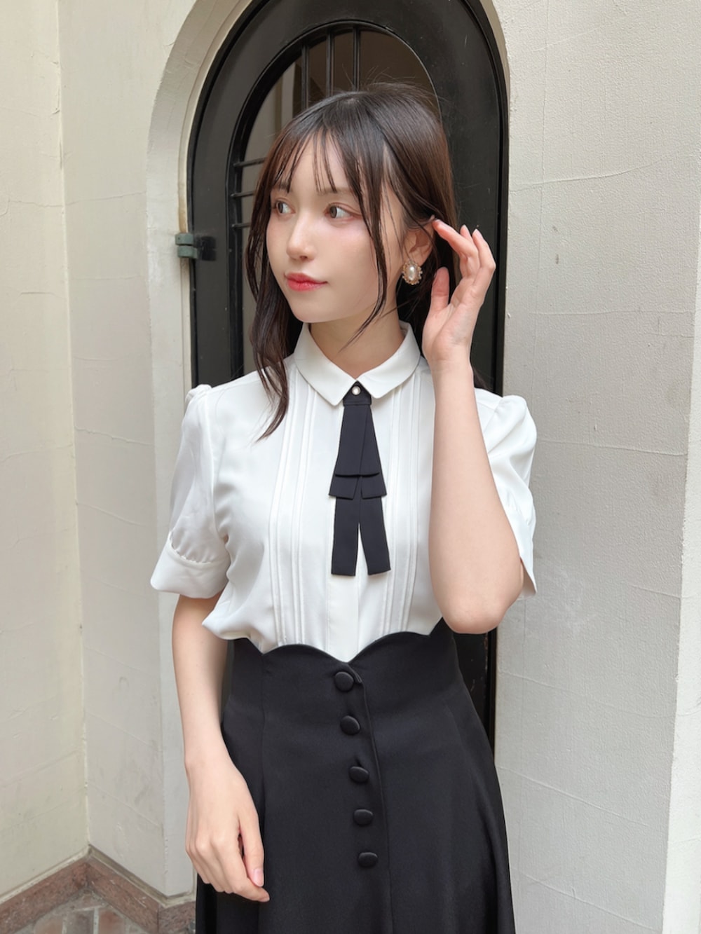 ブラック系のパンプス、ホワイト系のシャツ/ブラウス、ブラック系のスカートを着用したレディースの春コーディネートの3枚目の写真