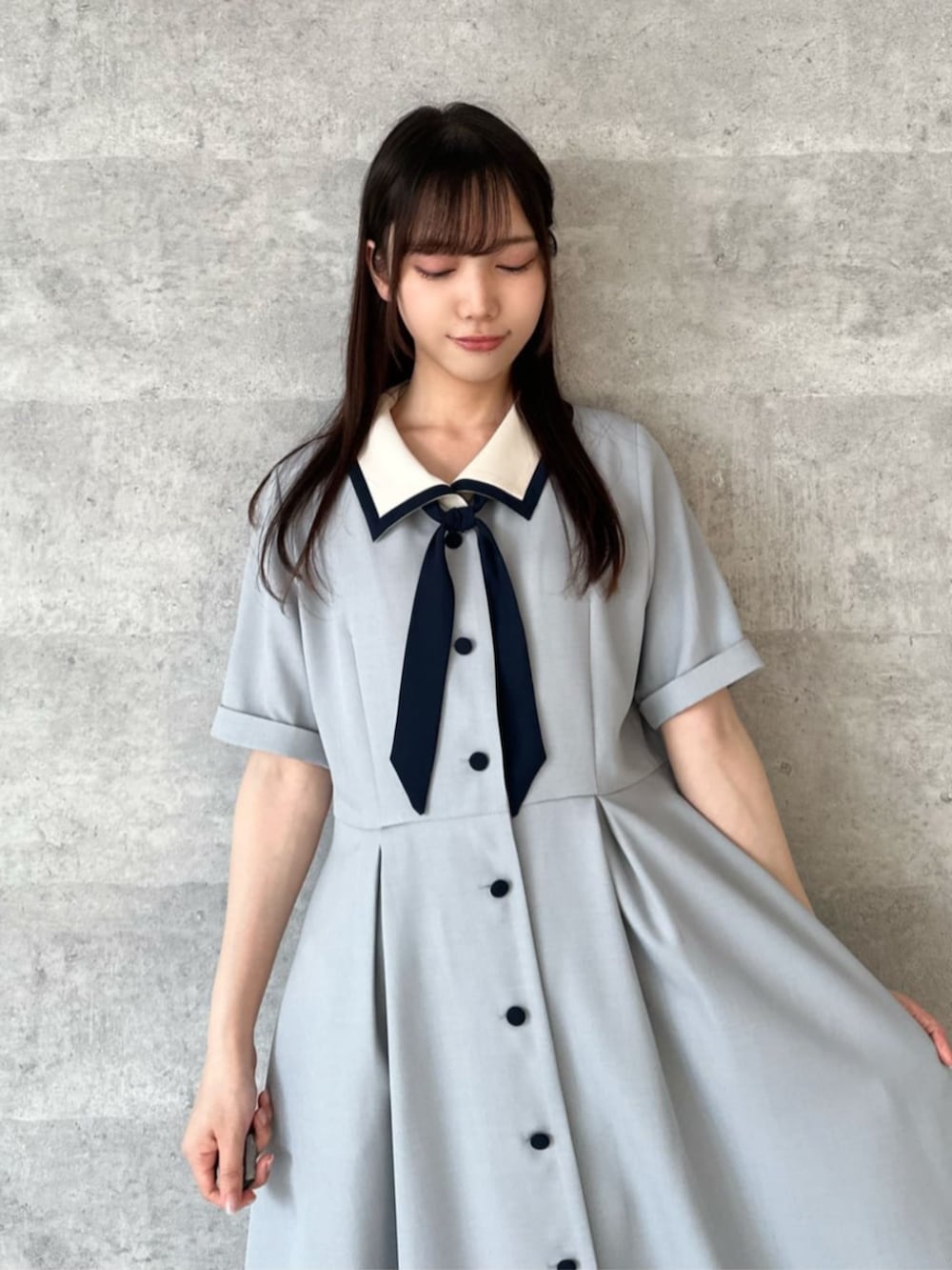ベージュ系のハンドバッグ、ホワイト系のサンダル、グレー系のワンピースを着用したレディースの夏コーディネートの3枚目の写真