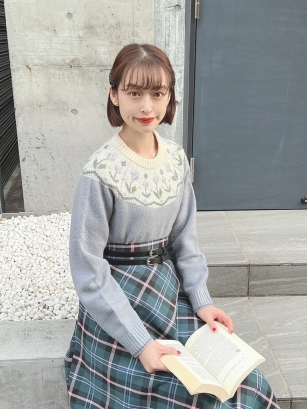 ブラック系のローファー、ブルー系のニット/セーター、ブルー系のスカートを着用したレディースの冬コーディネートの2枚目の写真