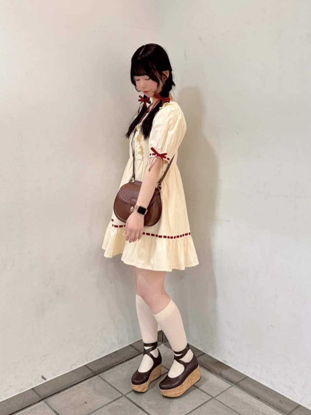 ブラウン系のパンプス、ブラウン系のショルダーバッグ、レッド系のカーディガン/ボレロを着用したレディースの春コーディネートの3枚目の写真