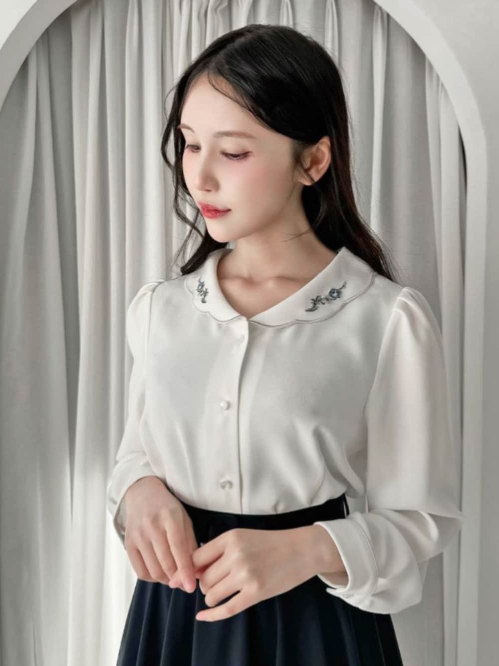 ブラック系のローファー、ブルー系のスカート、ホワイト系のシャツ/ブラウスを着用したレディースの冬コーディネートの2枚目の写真