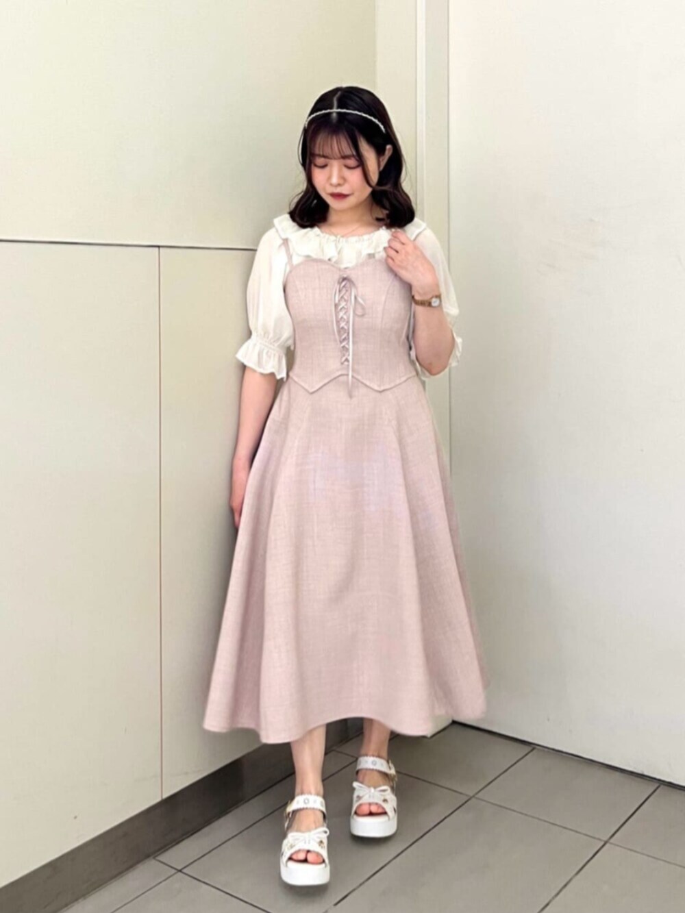 ピンク系のワンピース、ホワイト系のTシャツ/カットソー、ホワイト系のサンダルを着用したレディースの夏コーディネートの2枚目の写真