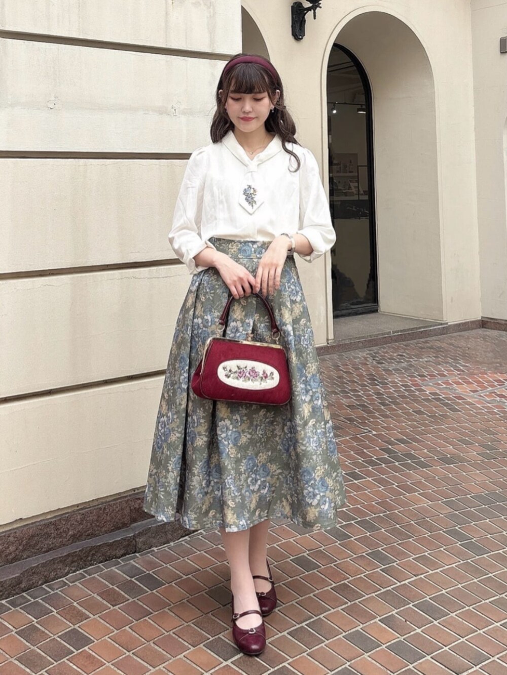 グリーン系のスカート、ホワイト系のシャツ/ブラウス、レッド系のパンプスを着用したレディースの秋コーディネートの2枚目の写真