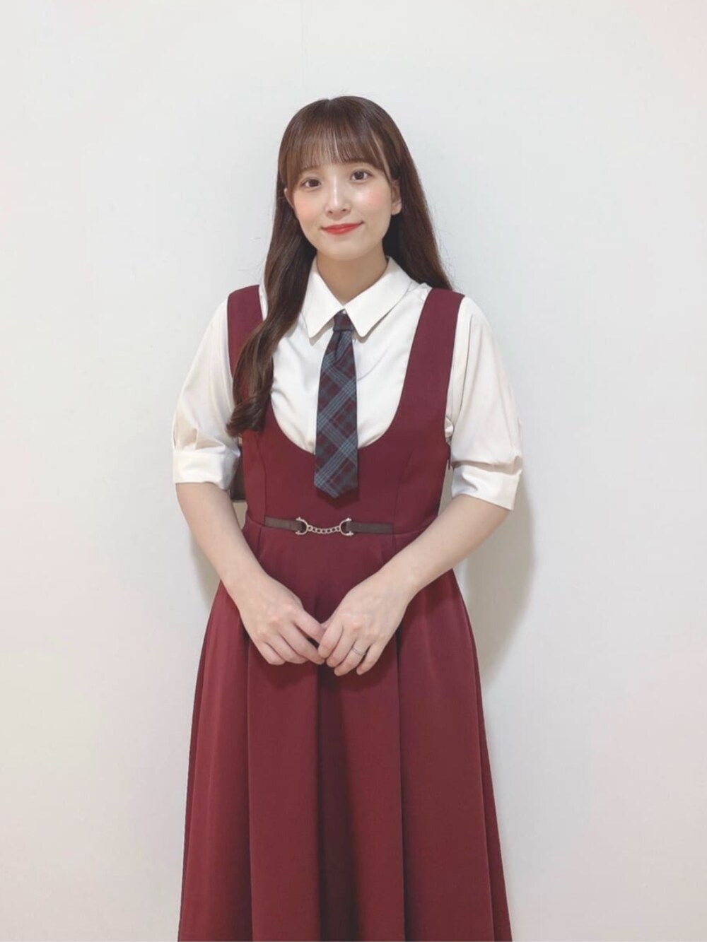 ベージュ系のハンドバッグ、ブラウン系のパンプス、レッド系のジャンパースカートを着用したレディースの夏コーディネートの3枚目の写真