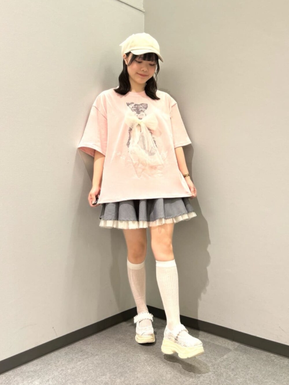 グレー系のスカート、ホワイト系のパーカー、ホワイト系のサンダルを着用したレディースの春コーディネートの3枚目の写真