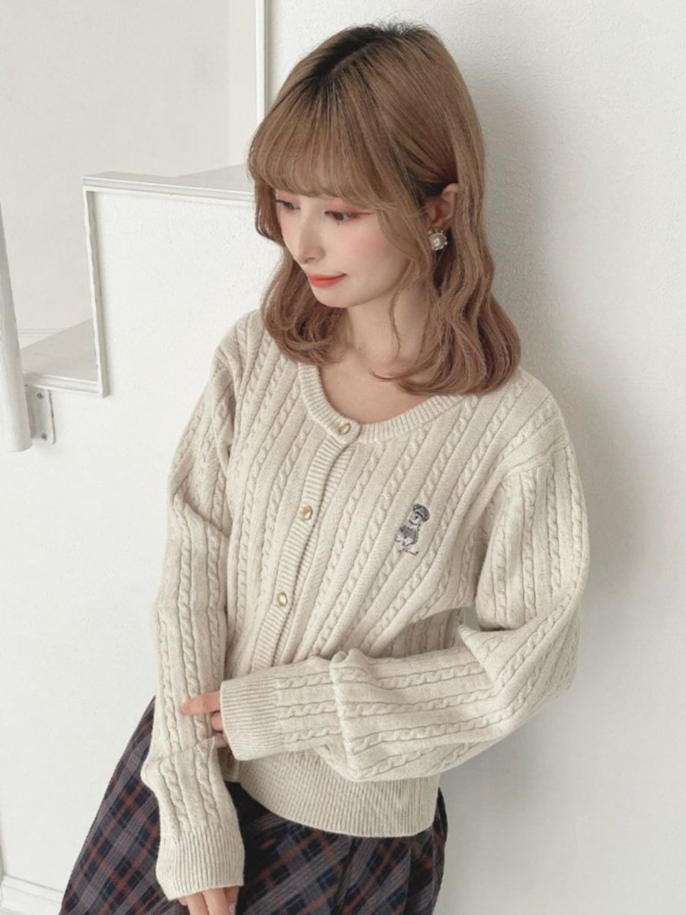 ブルー系のスカート、ホワイト系のカーディガン/ボレロ、ブラウン系のブーツを着用したレディースの秋コーディネートの2枚目の写真