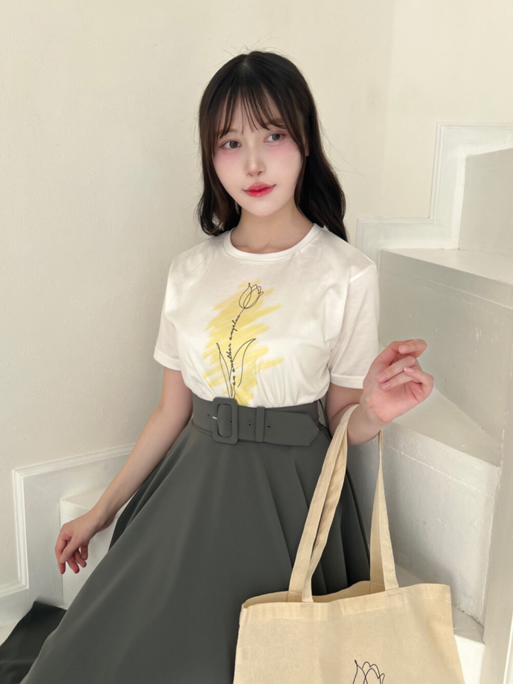 グリーン系のスカート、イエロー系のTシャツ/カットソーを着用したレディースの夏コーディネートの2枚目の写真