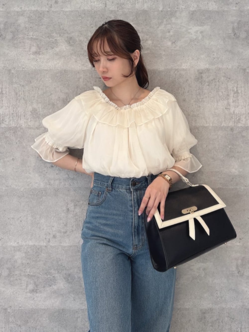 ブルー系のデニムパンツ、ブラック系のハンドバッグ、ブラック系のパンプスを着用したレディースの夏コーディネートの3枚目の写真