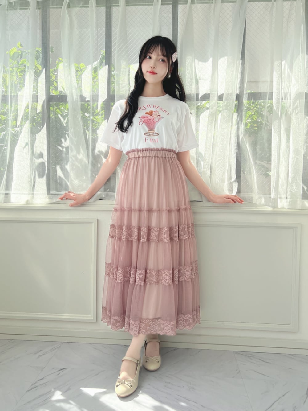 ベージュ系のパンプス、ピンク系のスカート、ホワイト系のTシャツ/カットソーを着用したレディースの夏コーディネートの2枚目の写真