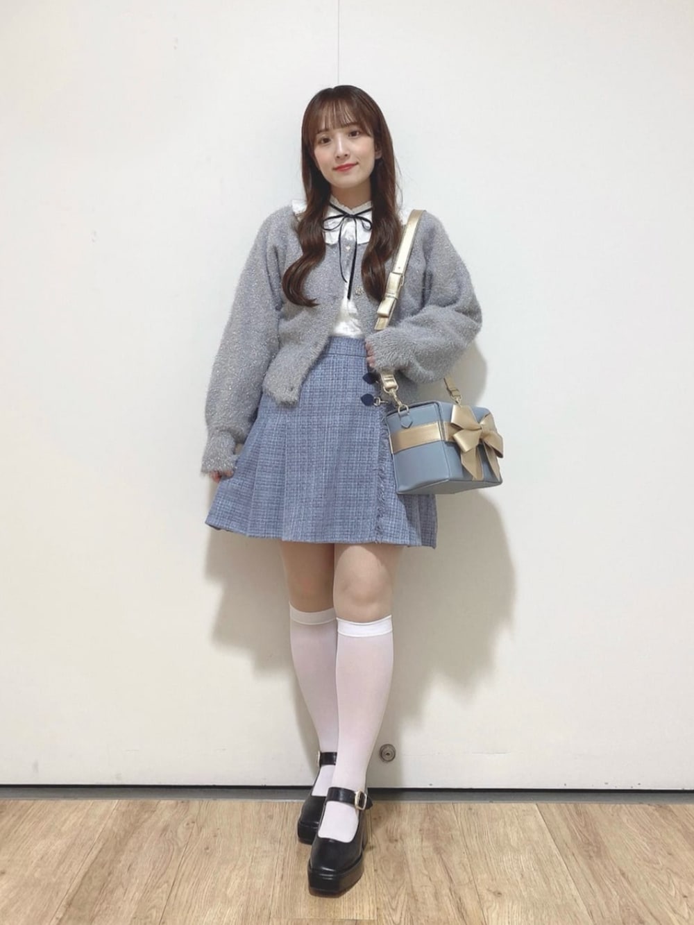 ブラック系のパンプス、ホワイト系のシャツ/ブラウス、グレー系のスカートを着用したレディースの秋コーディネートの2枚目の写真