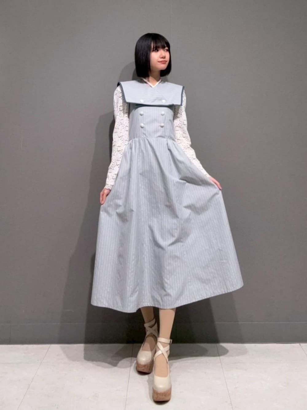 ホワイト系のパンプス、ホワイト系のTシャツ/カットソー、ブルー系のワンピースを着用したレディースの春コーディネートの2枚目の写真