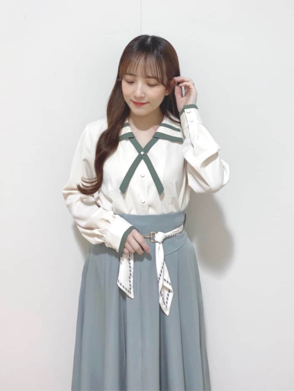 ブラウン系のローファー、ホワイト系のシャツ/ブラウス、グリーン系のスカートを着用したレディースの春コーディネートの2枚目の写真