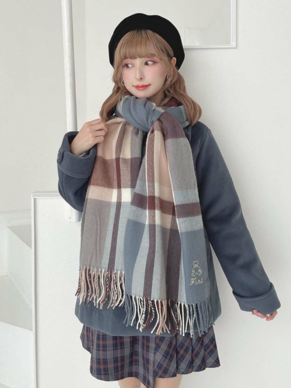 ブラック系のローファー、ブルー系のスカート、グレー系のピーコートを着用したレディースの秋コーディネートの3枚目の写真