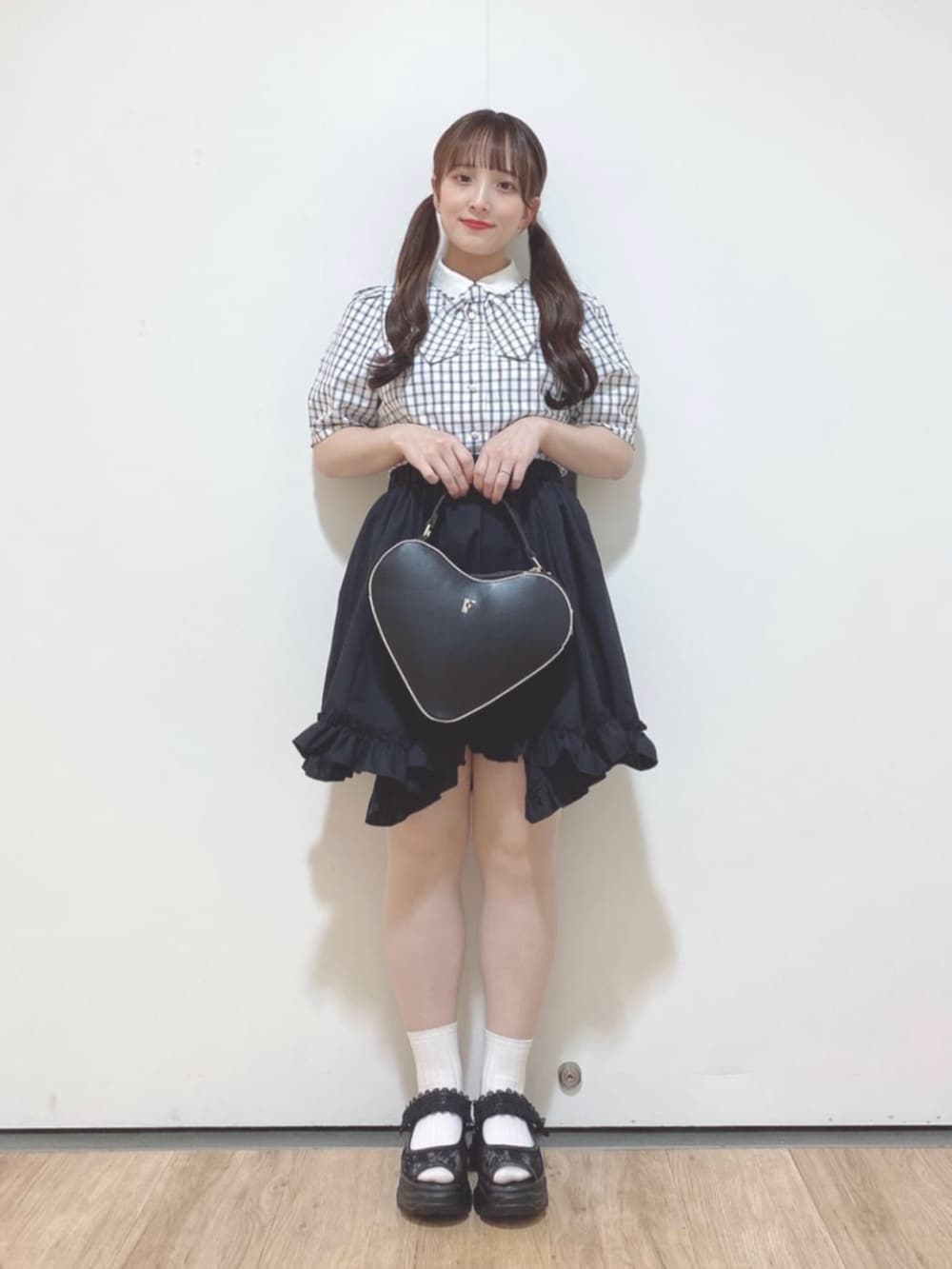 ホワイト系のシャツ/ブラウス、ブラック系のスカート、ブラック系のハンドバッグを着用したレディースの春コーディネートの2枚目の写真