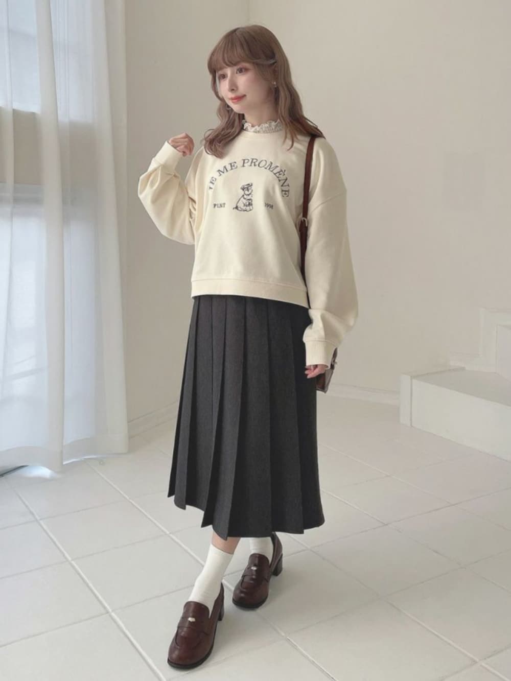 ブラウン系のローファー、ホワイト系のTシャツ/カットソー、ブラウン系のショルダーバッグを着用したレディースの冬コーディネートの2枚目の写真