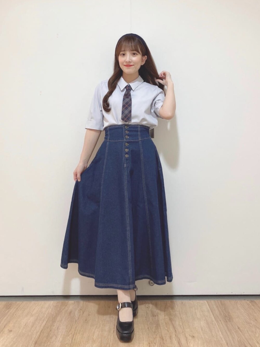 ブルー系のデニムスカート、ブラック系のパンプス、グレー系のTシャツ/カットソーを着用したレディースの夏コーディネートの2枚目の写真