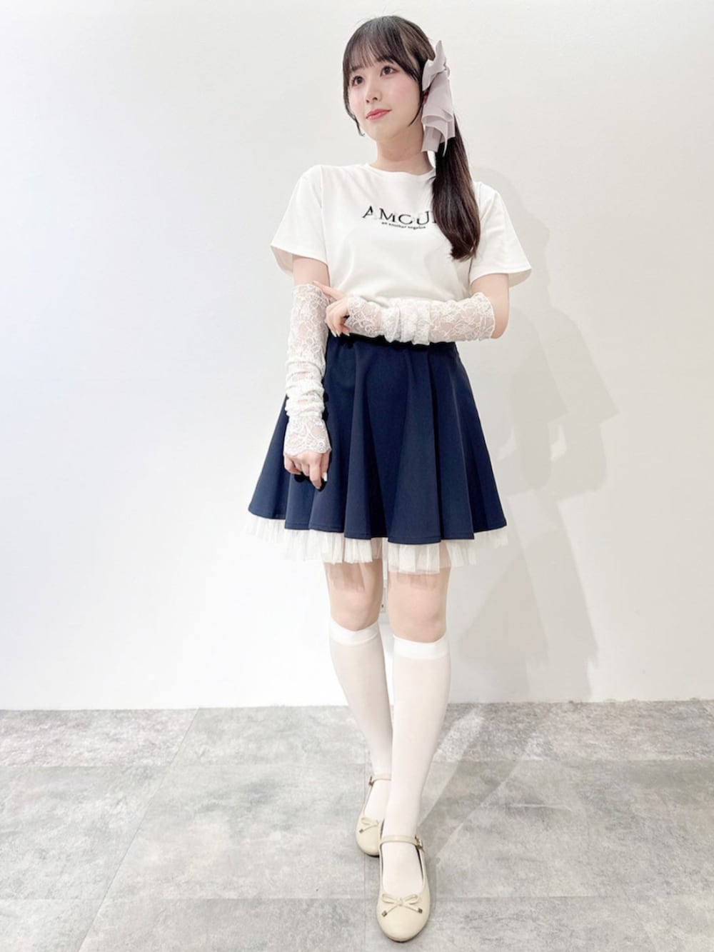 ベージュ系のバレエシューズ、ホワイト系のTシャツ/カットソー、ブルー系のスカートを着用したレディースの春コーディネートの2枚目の写真