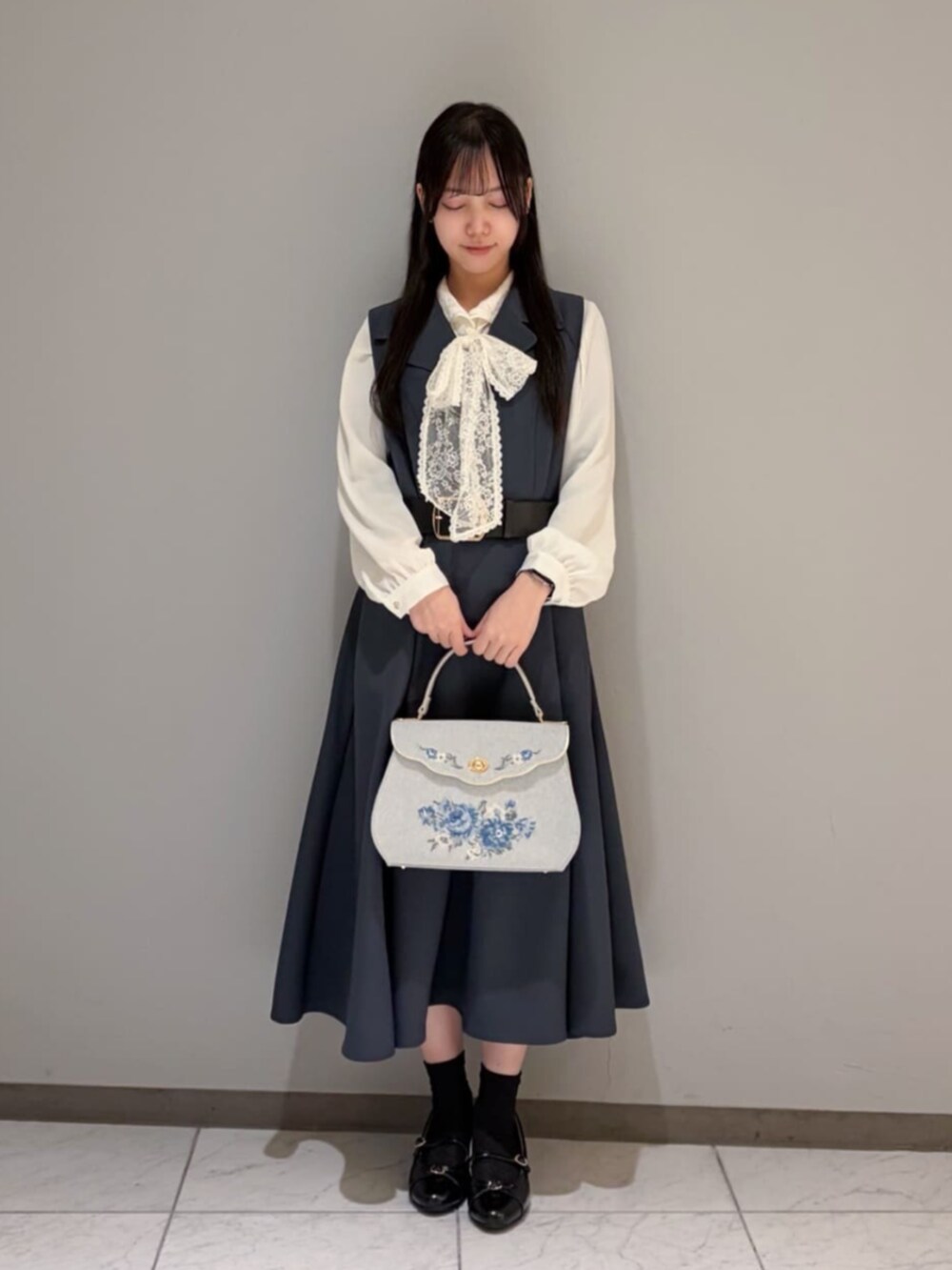 ブラック系のパンプス、ホワイト系のシャツ/ブラウス、グレー系のワンピースを着用したレディースの冬コーディネートの2枚目の写真