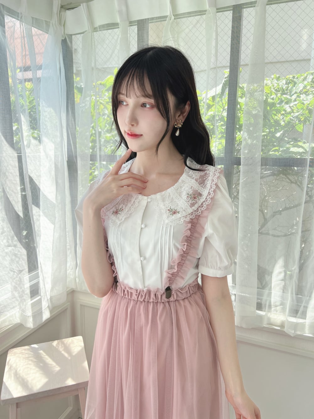 ピンク系のスカート、ベージュ系のパンプス、ホワイト系のシャツ/ブラウスを着用したレディースの夏コーディネートの2枚目の写真