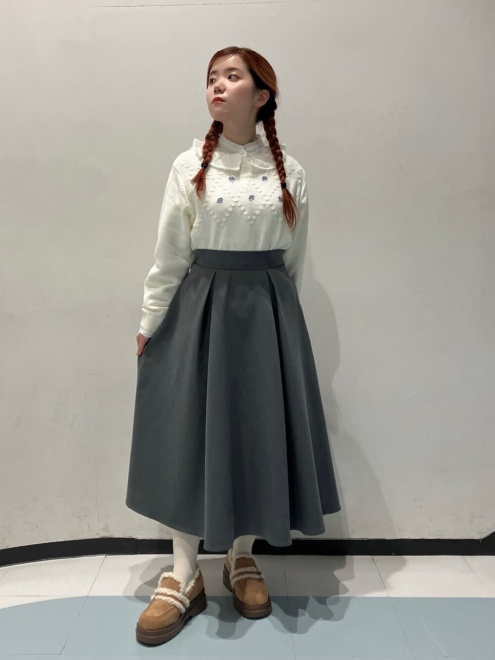ホワイト系のシャツ/ブラウス、ベージュ系のモカシン/デッキシューズ、グレー系のスカートを着用したレディースの冬コーディネートの2枚目の写真