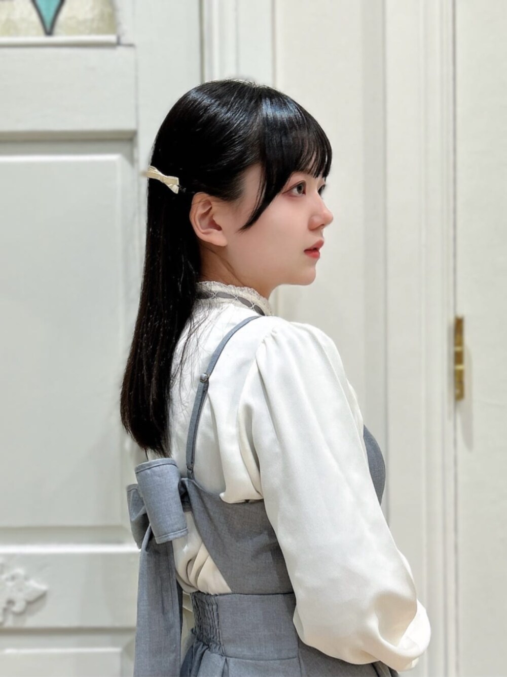 ホワイト系のシャツ/ブラウス、ホワイト系のパンプス、グレー系のワンピースを着用したレディースの春コーディネートの3枚目の写真