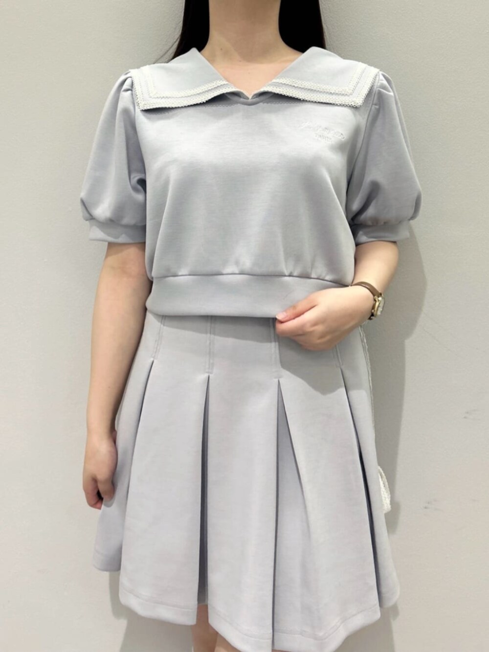 ブルー系のスカート、ホワイト系のハンドバッグ、ホワイト系のサンダルを着用したレディースの夏コーディネートの3枚目の写真