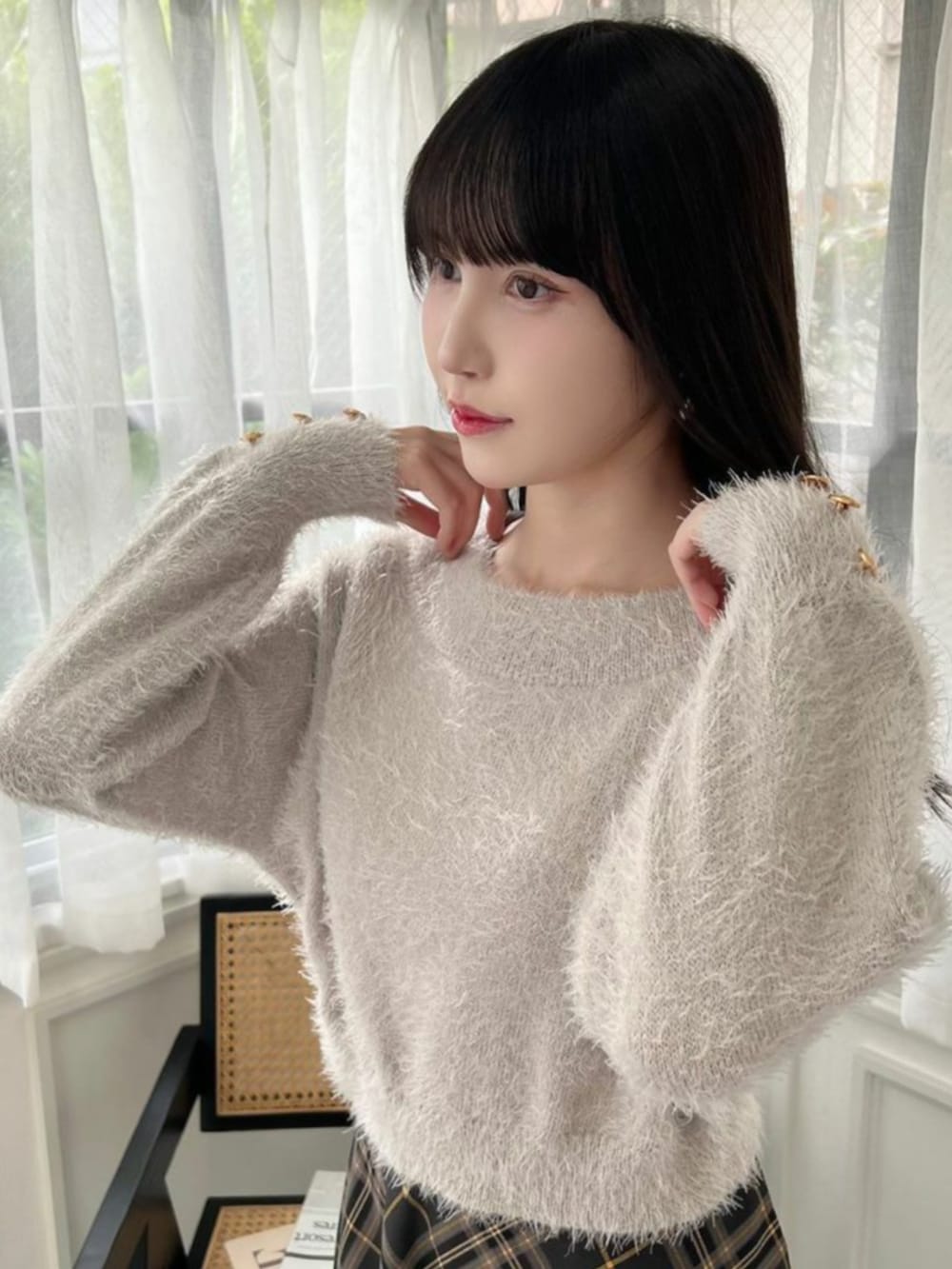 ブラック系のパンプス、ブラック系のスカート、グレー系のニット/セーターを着用したレディースの秋コーディネートの2枚目の写真