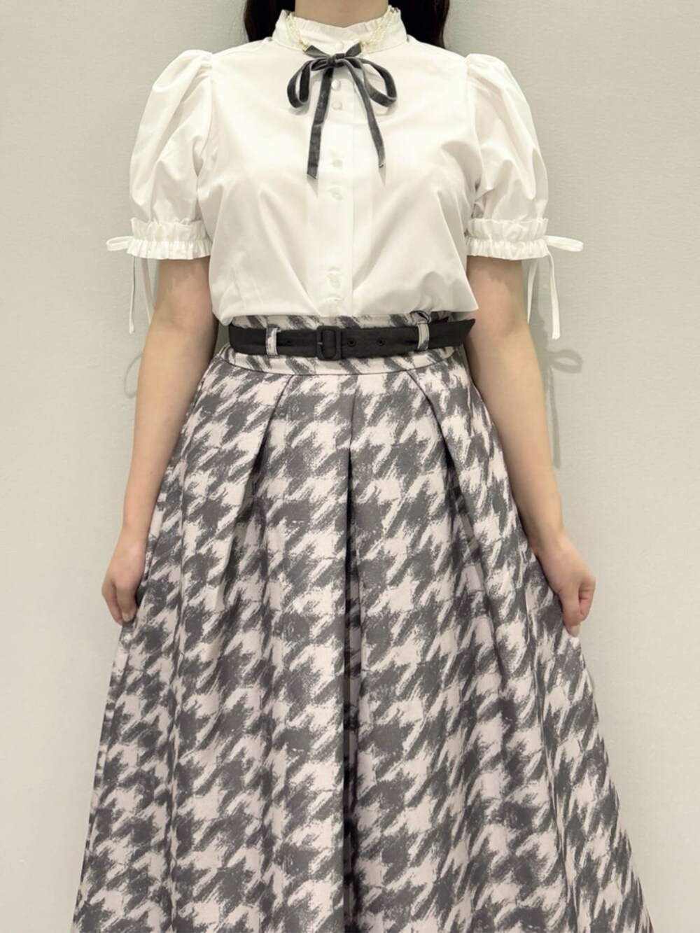 グレー系のスカート、ピンク系のセットアップ、ホワイト系のシャツ/ブラウスを着用したレディースの秋コーディネートの10枚目の写真