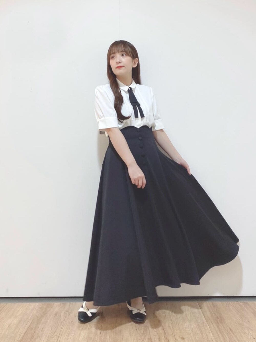 ブラック系のパンプス、ホワイト系のシャツ/ブラウス、ブラック系のスカートを着用したレディースの夏コーディネートの2枚目の写真