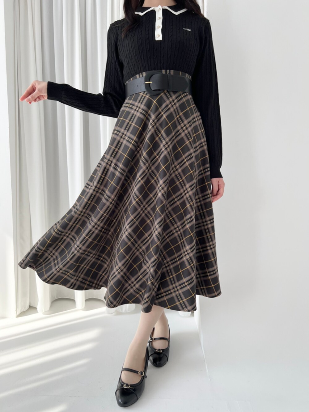 ブラック系のパンプス、ブラック系のスカート、ブラック系のニット/セーターを着用したレディースの秋コーディネートの3枚目の写真