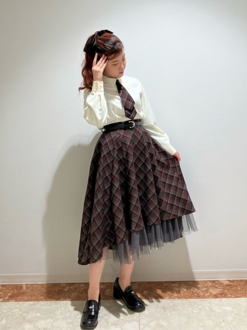 ブラック系のローファー、ブラック系のスカート、ホワイト系のシャツ/ブラウスを着用したレディースの冬コーディネートの2枚目の写真