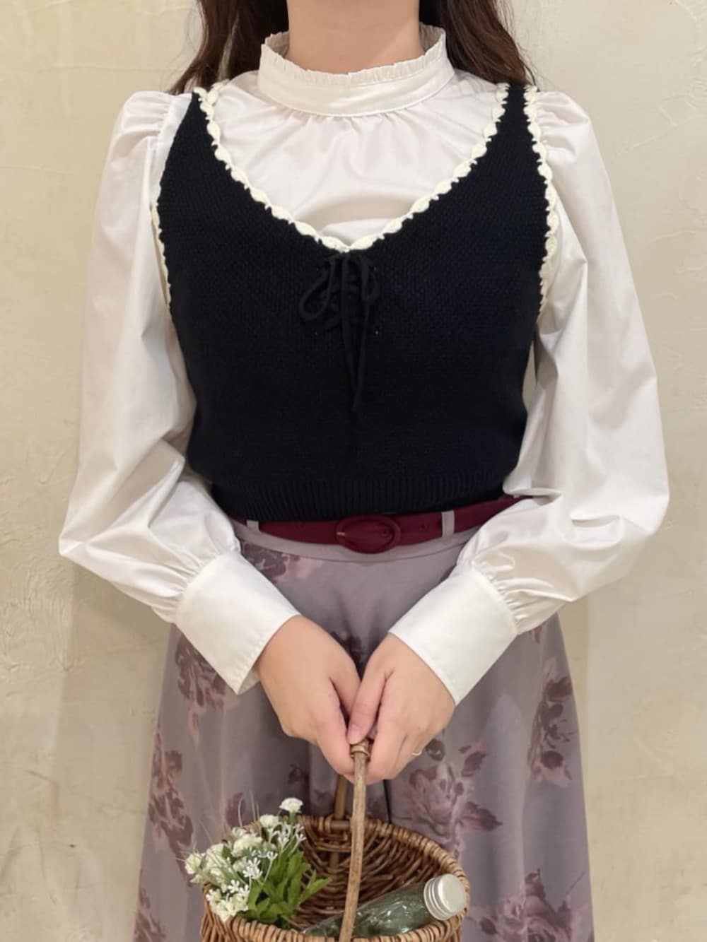 ブラック系のベスト、ホワイト系のシャツ/ブラウス、レッド系のスカートを着用したレディースの秋コーディネートの4枚目の写真