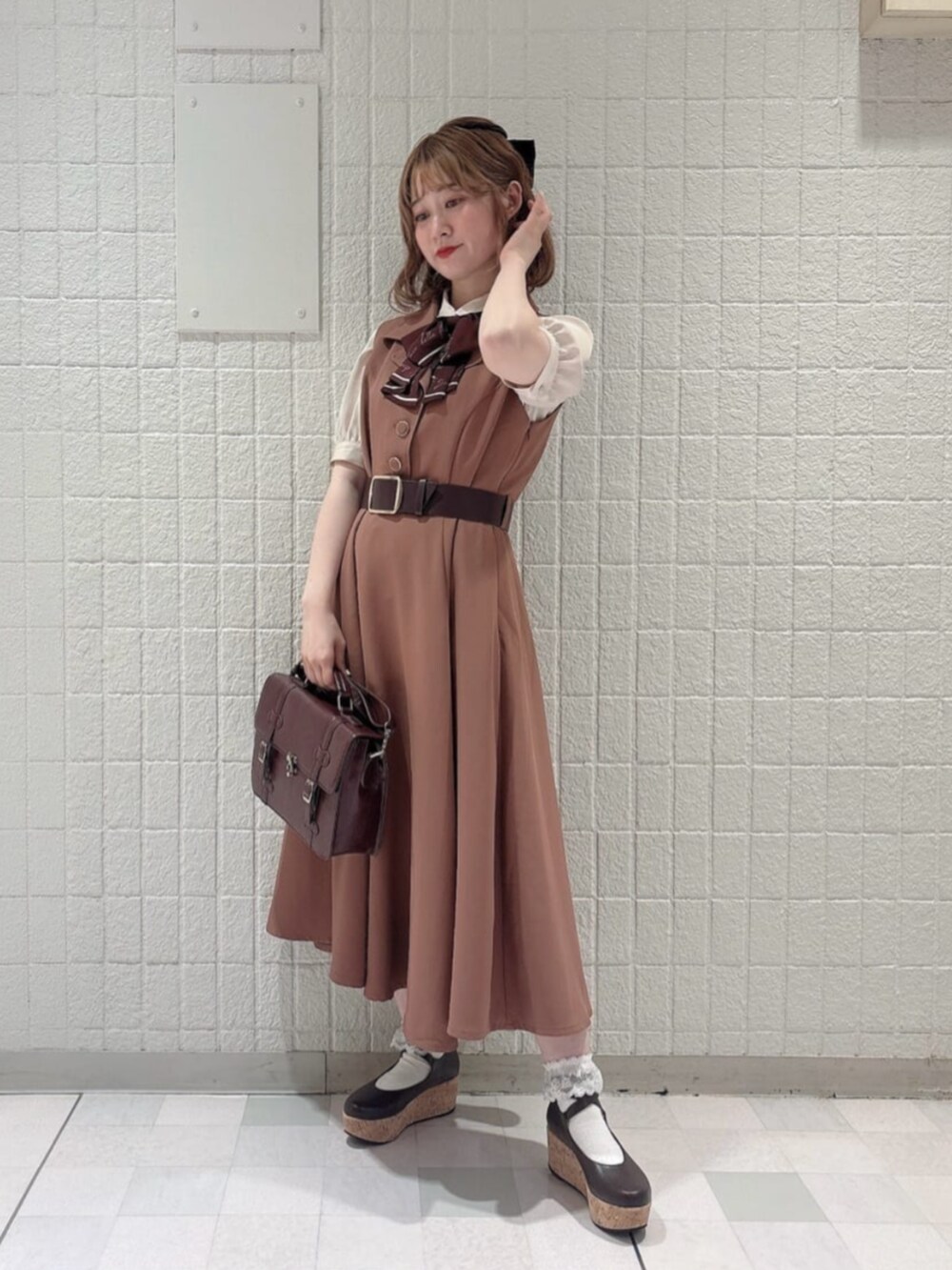 レッド系のワンピース、ベージュ系のシャツ/ブラウス、ブラウン系のショルダーバッグを着用したレディースの夏コーディネートの2枚目の写真