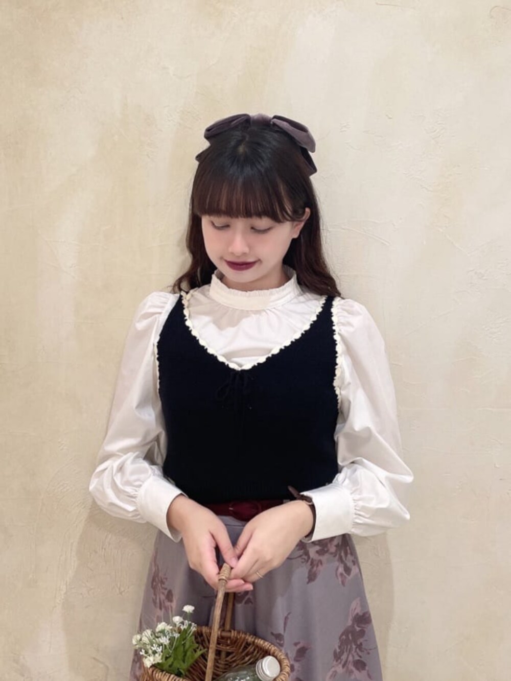 ブラック系のベスト、ホワイト系のシャツ/ブラウス、レッド系のスカートを着用したレディースの秋コーディネートの3枚目の写真