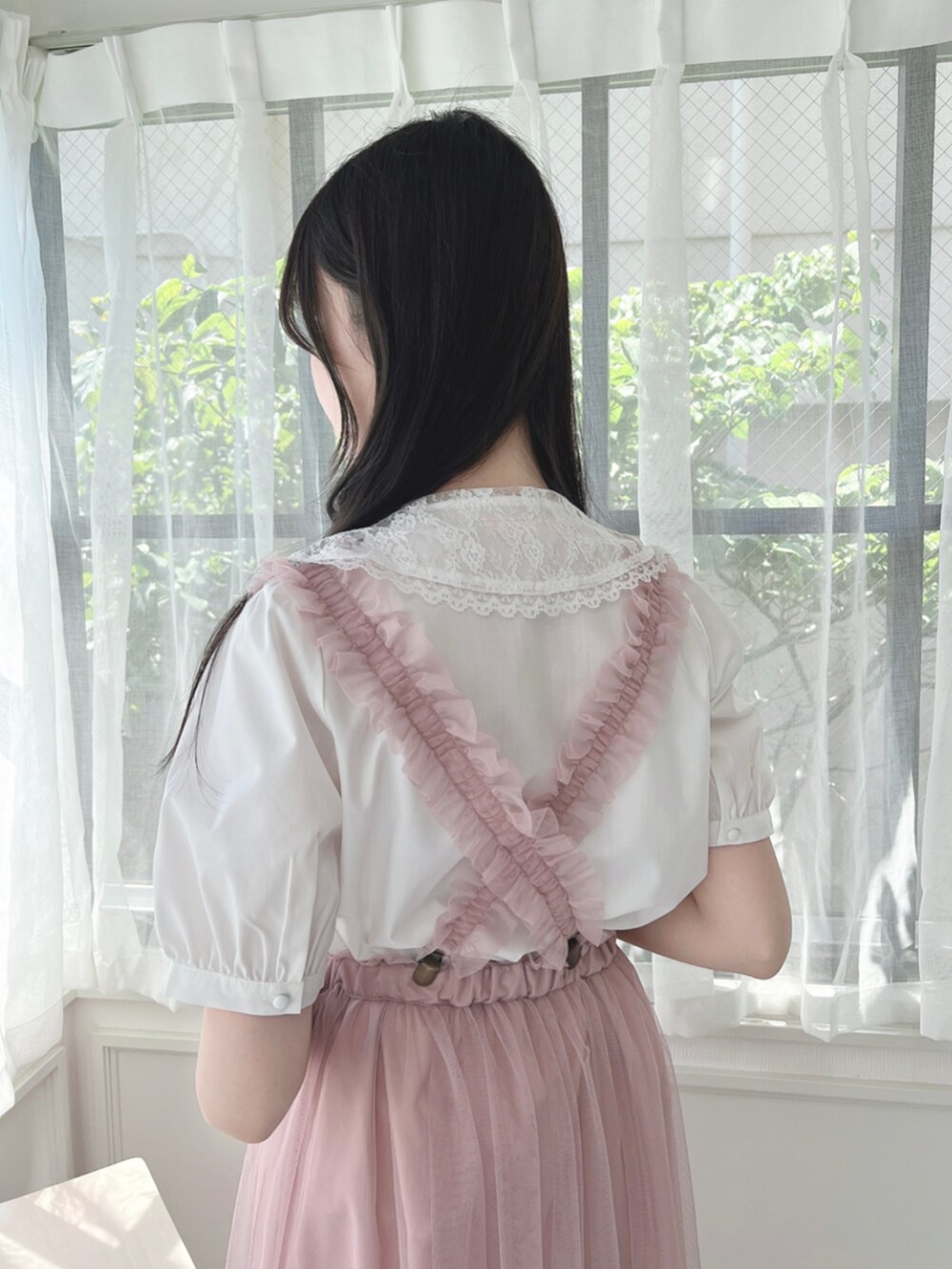 ピンク系のスカート、ベージュ系のパンプス、ホワイト系のシャツ/ブラウスを着用したレディースの夏コーディネートの3枚目の写真