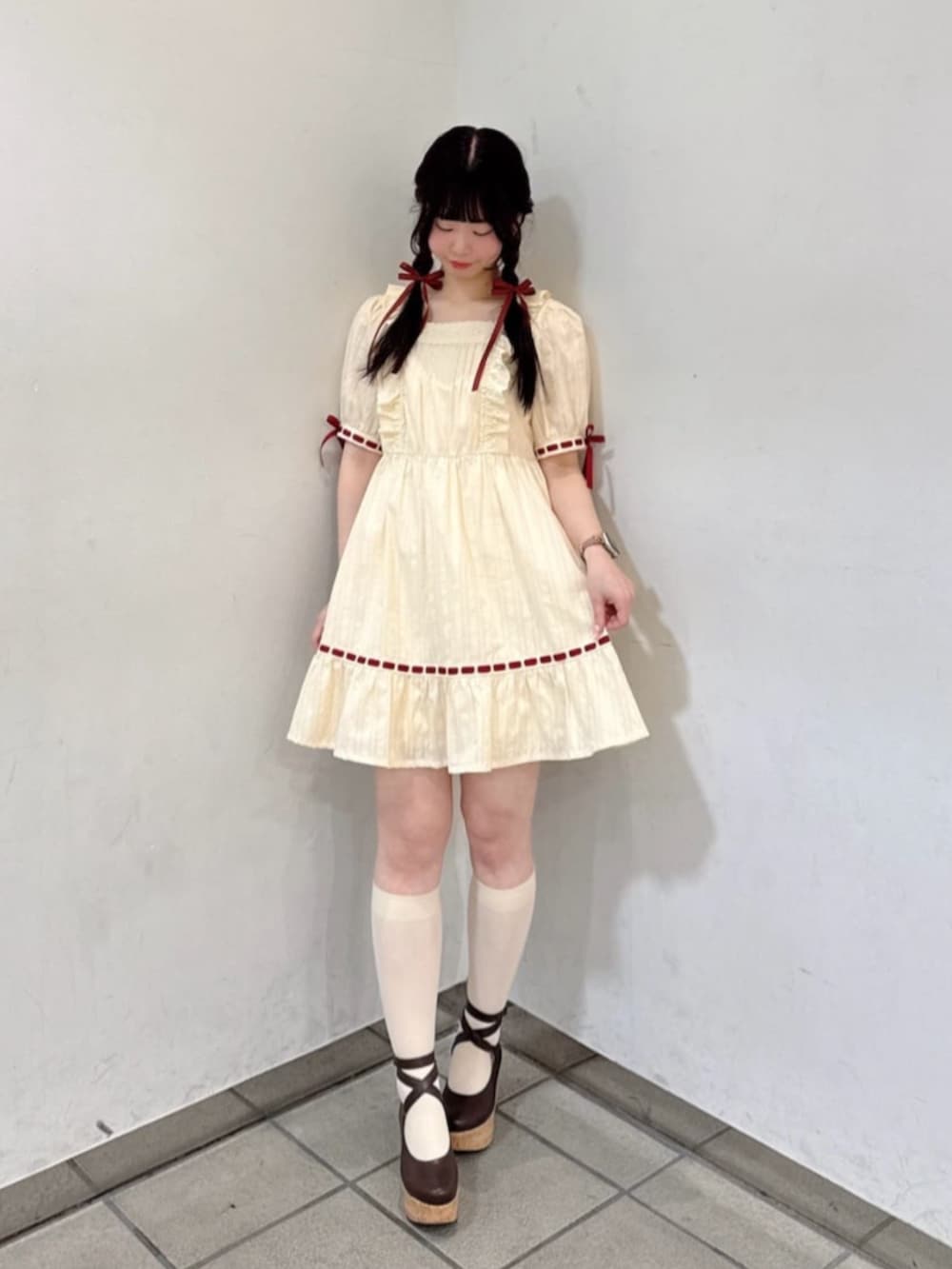 ブラウン系のパンプス、ブラウン系のショルダーバッグ、レッド系のカーディガン/ボレロを着用したレディースの春コーディネートの2枚目の写真