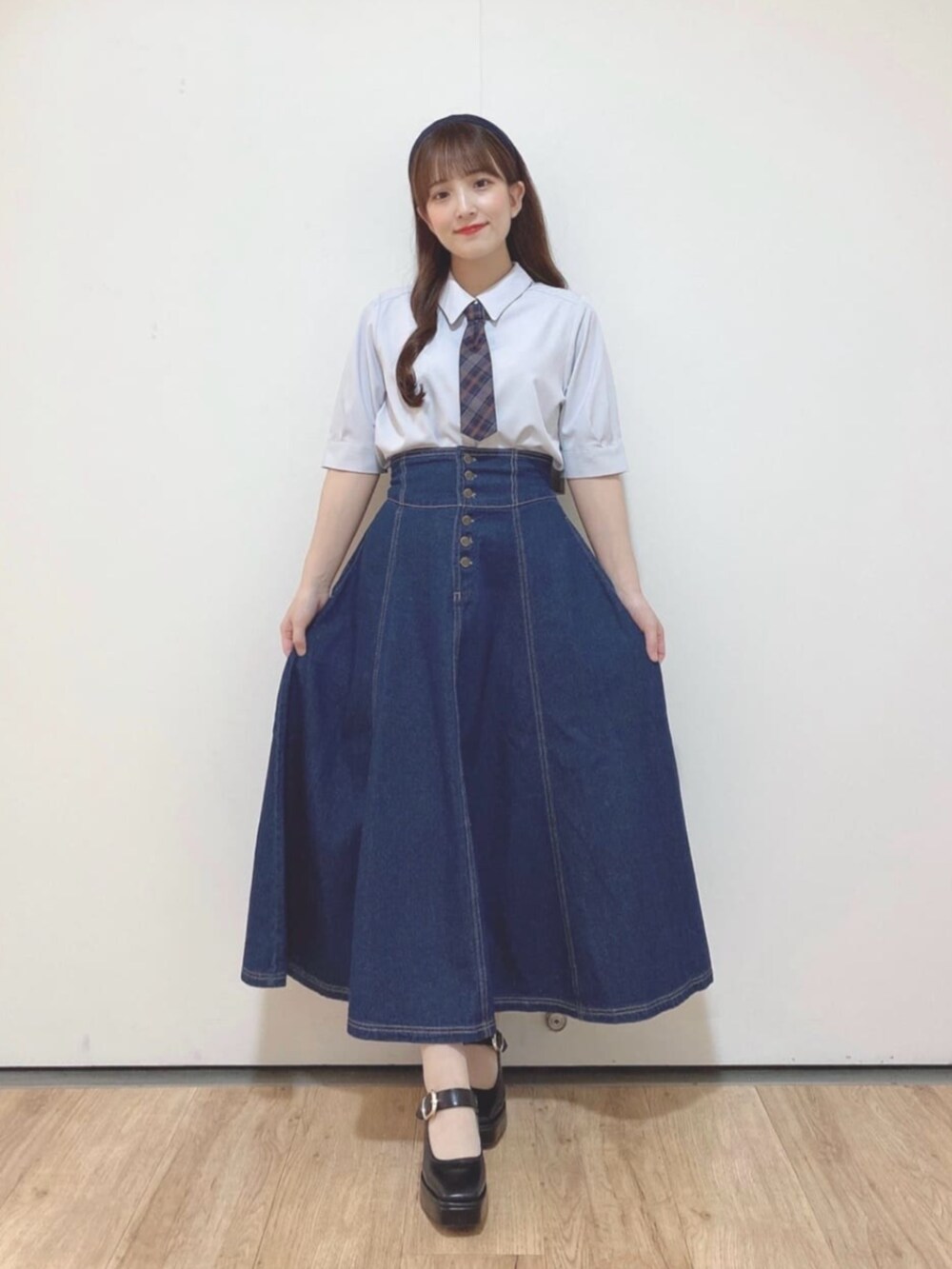 ブルー系のデニムスカート、ブラック系のパンプス、グレー系のTシャツ/カットソーを着用したレディースの夏コーディネートの3枚目の写真