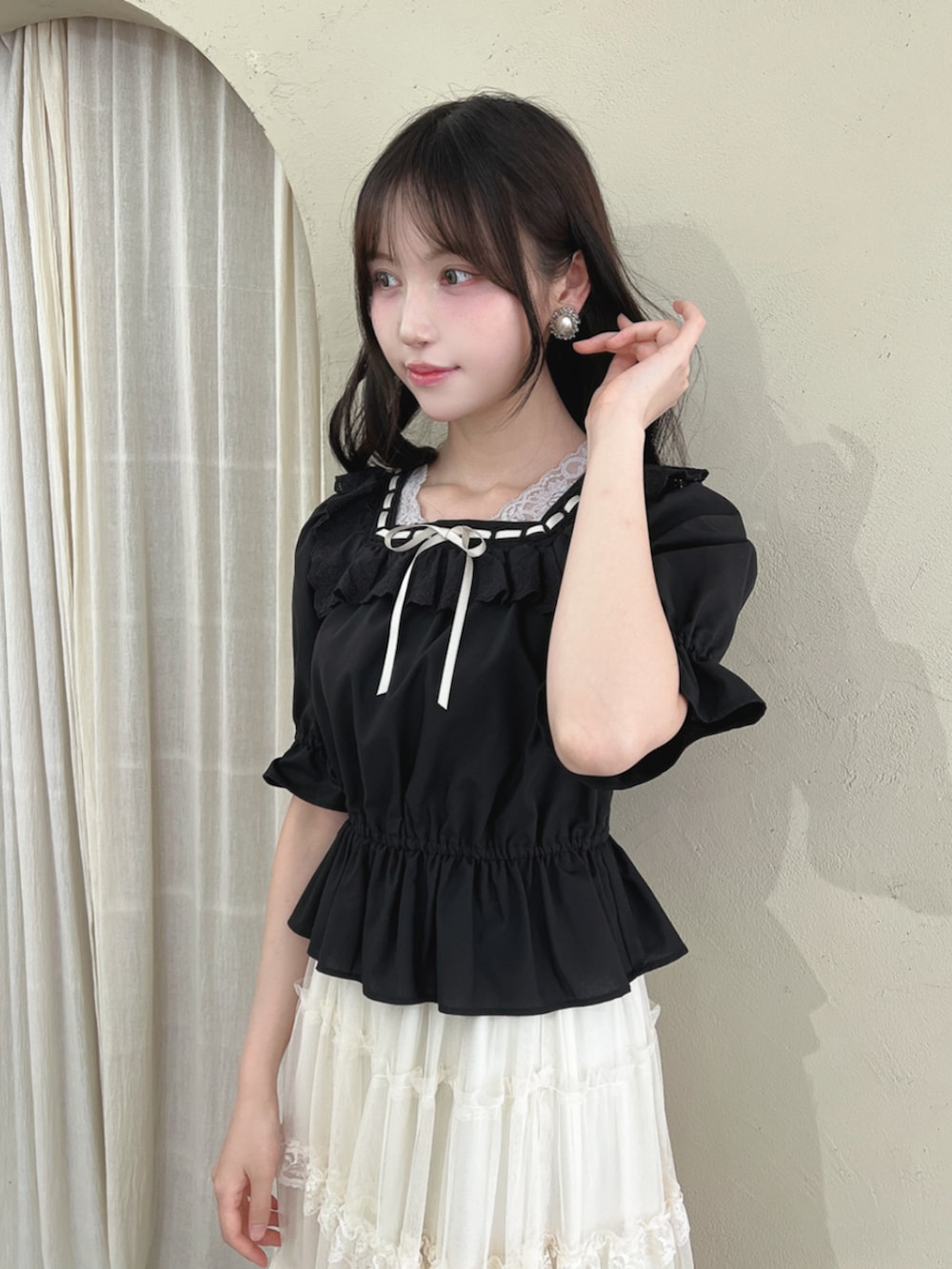 ブラック系のパンプス、ホワイト系のスカート、ブラック系のシャツ/ブラウスを着用したレディースの夏コーディネートの2枚目の写真