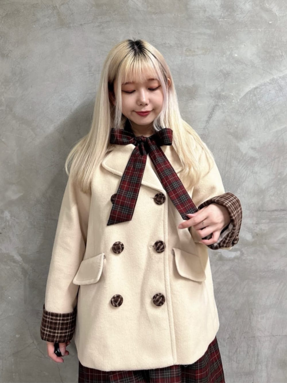 ベージュ系のピーコート、レッド系のワンピースを着用したレディースの秋コーディネートの3枚目の写真