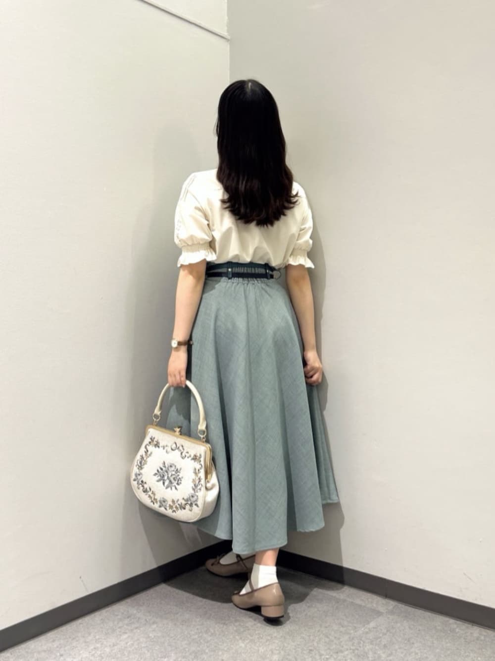 ブラウン系のレインシューズ、ブルー系のスカート、ベージュ系のシャツ/ブラウスを着用したレディースの夏コーディネートの2枚目の写真