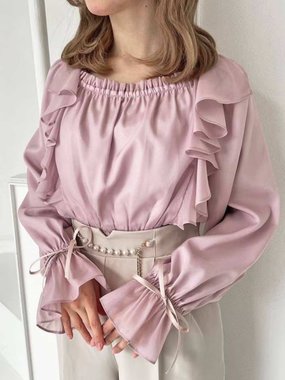 ピンク系のシャツ/ブラウス、ベージュ系のパンツを着用したレディースの春コーディネートの3枚目の写真