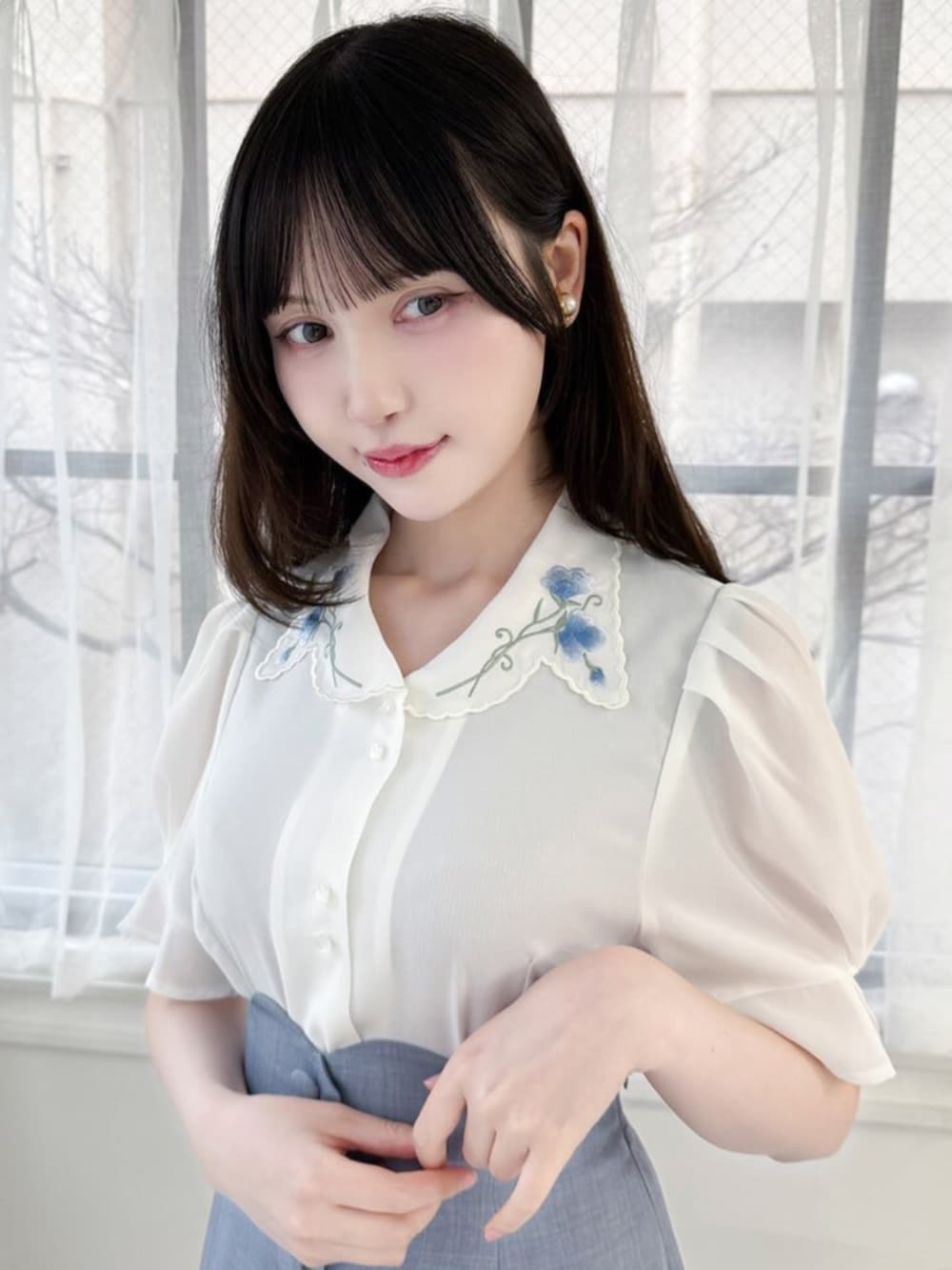 ブルー系のハンドバッグ、ホワイト系のパンプス、ホワイト系のシャツ/ブラウスを着用したレディースの春コーディネートの2枚目の写真