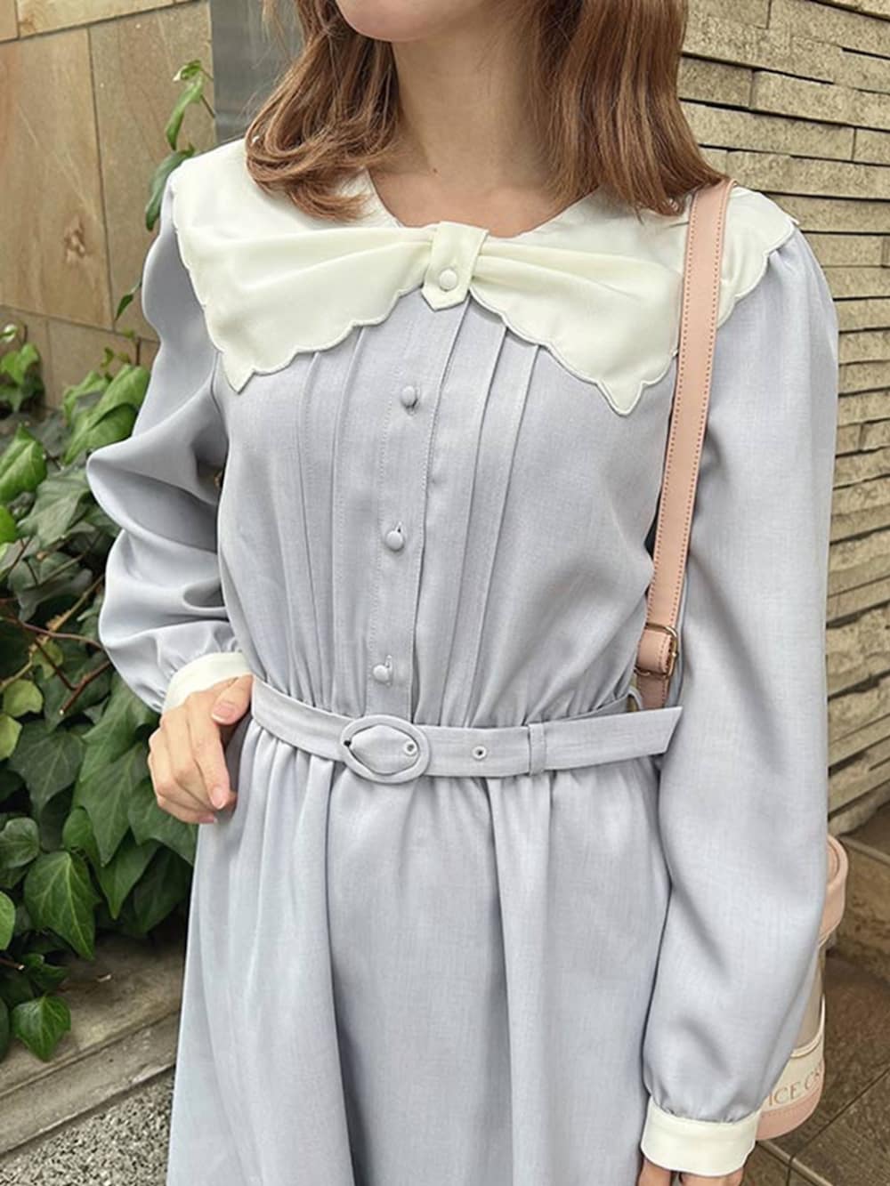 ホワイト系のパンプス、ピンク系のショルダーバッグ、ブルー系のワンピースを着用したレディースの冬コーディネートの3枚目の写真