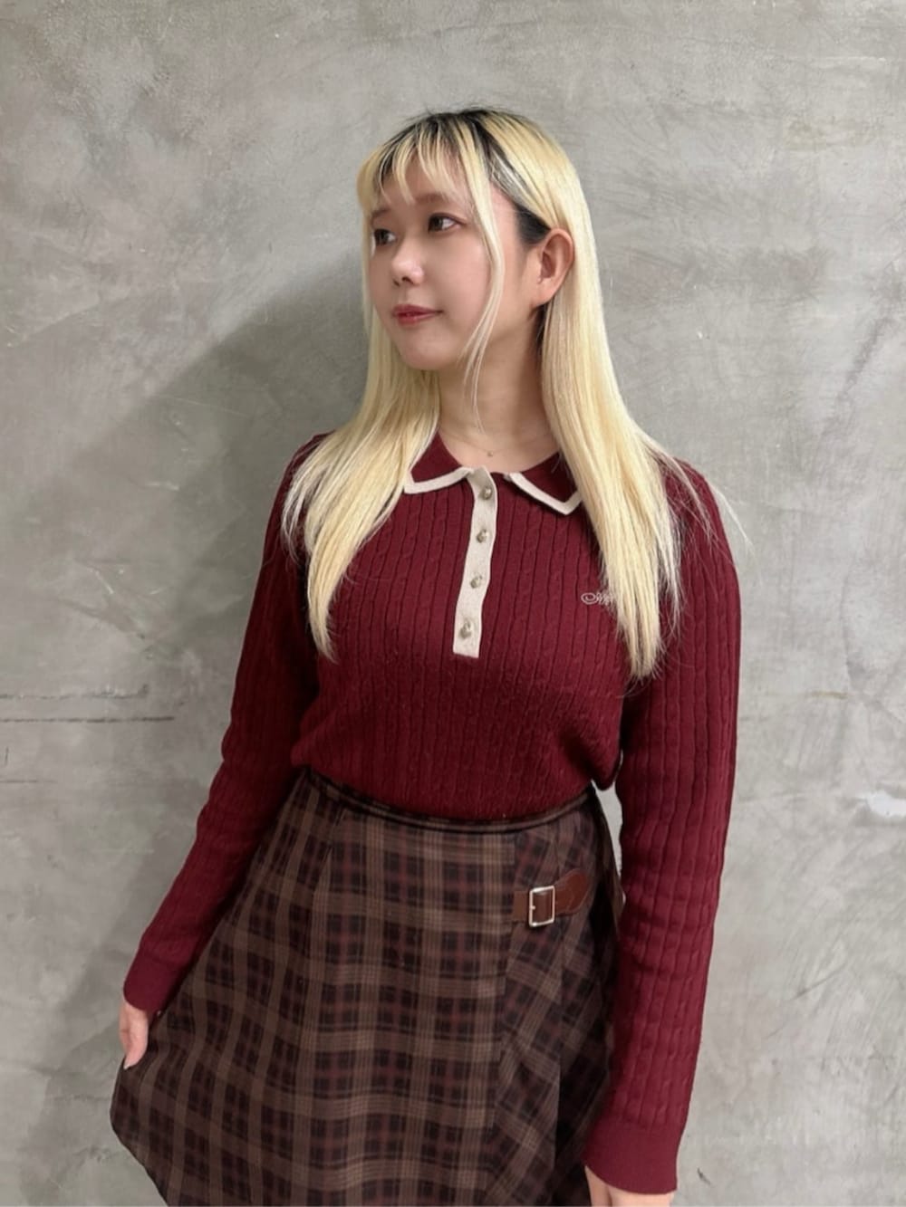 ブラウン系のスカート、ブラウン系のブーツ、レッド系のニット/セーターを着用したレディースの冬コーディネートの3枚目の写真