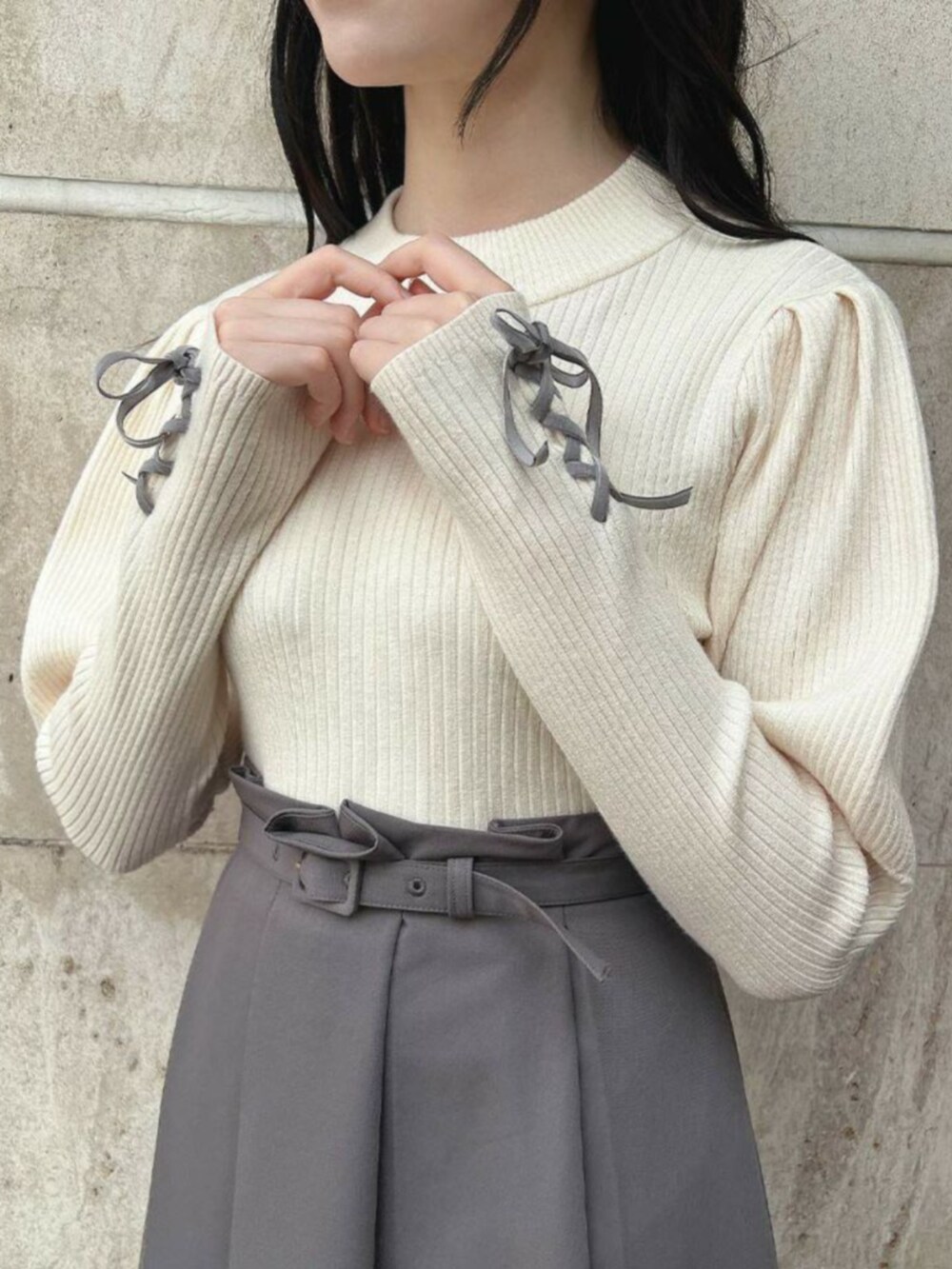 ブラック系のパンプス、グレー系のスカート、ホワイト系のニット/セーターを着用したレディースの秋コーディネートの3枚目の写真