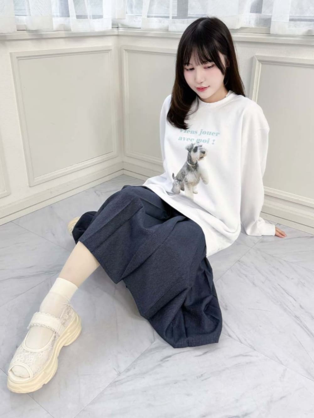 ブルー系のデニムスカート、グリーン系のスウェットを着用したレディースの春コーディネートの2枚目の写真